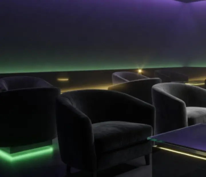 Sötét, atmoszférikus lounge enteriőr acid-zöld fényekkel a Lume Lounge-ban